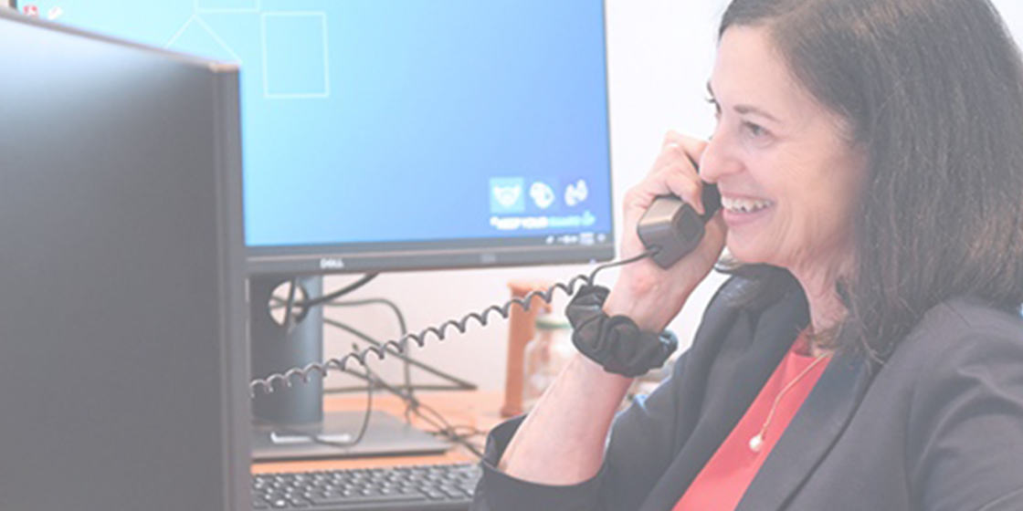 Judy Aschner at desk on phone