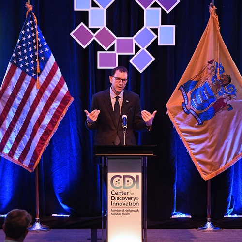 Dr. Perlin standing at a podium